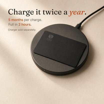 Trace Vault tracking card placed on a black wireless charging pad with the Trace Vault logo, showing convenient wireless charging.